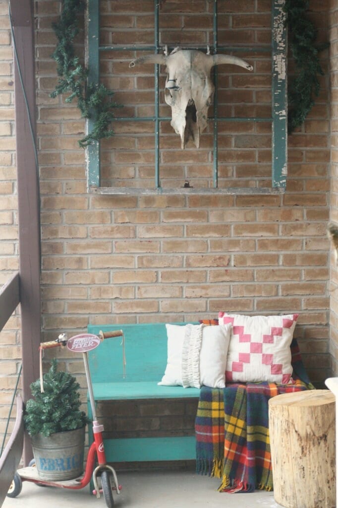 Christmas porch entry, vintage pillows and plaid blanket, turquoise bench and window, radio flyer scooter, bull skull