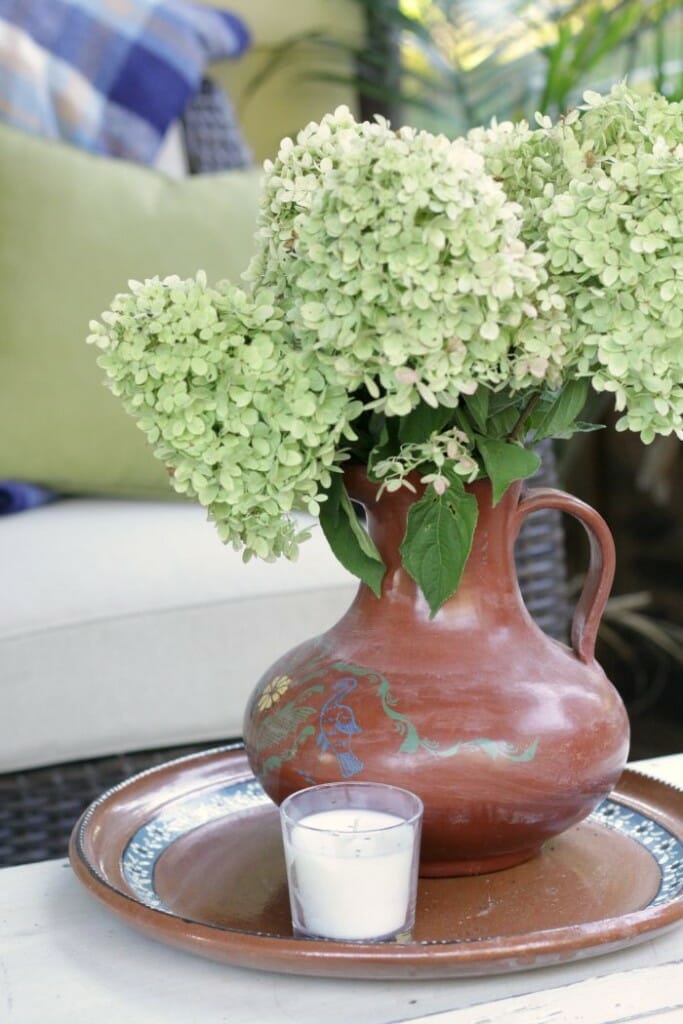 Mexican pitcher filled with hydrangeas on Fall porch