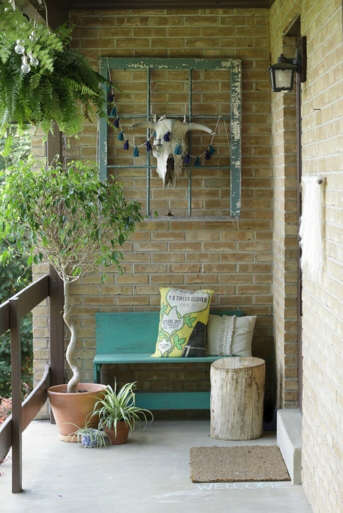Bohemian entry with teal bench and window, bull skull, spider plant, stump