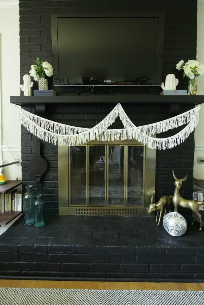Black Fireplace and Modern Boho Mantle with Fringe, Cacti, white peonies