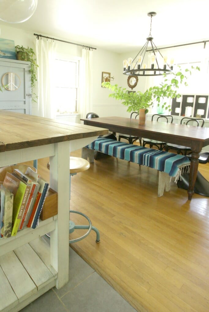 Eclectic Dining Room with Sarape on bench, industrial island dividing spaces