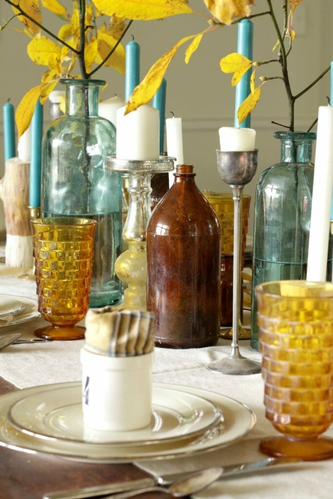 Mixed Metals Candlesticks and Vintage Bottles in Centerpiece