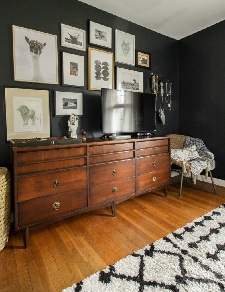 Midcentury Dresser with TV and gallery wall around it, black walls help hide TV