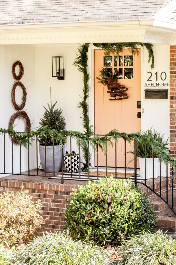 small whimsical christmas porch with orange door