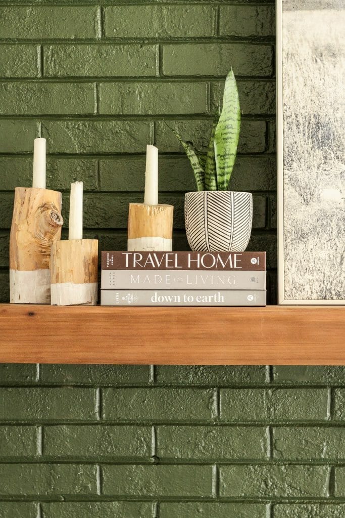 minimal mantel styling books and candle holders and plant